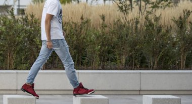 Milan, Italy - october 10, 2017: Young man wearing a pair of red Nike Jordan shoes in the street - illustrative editorial