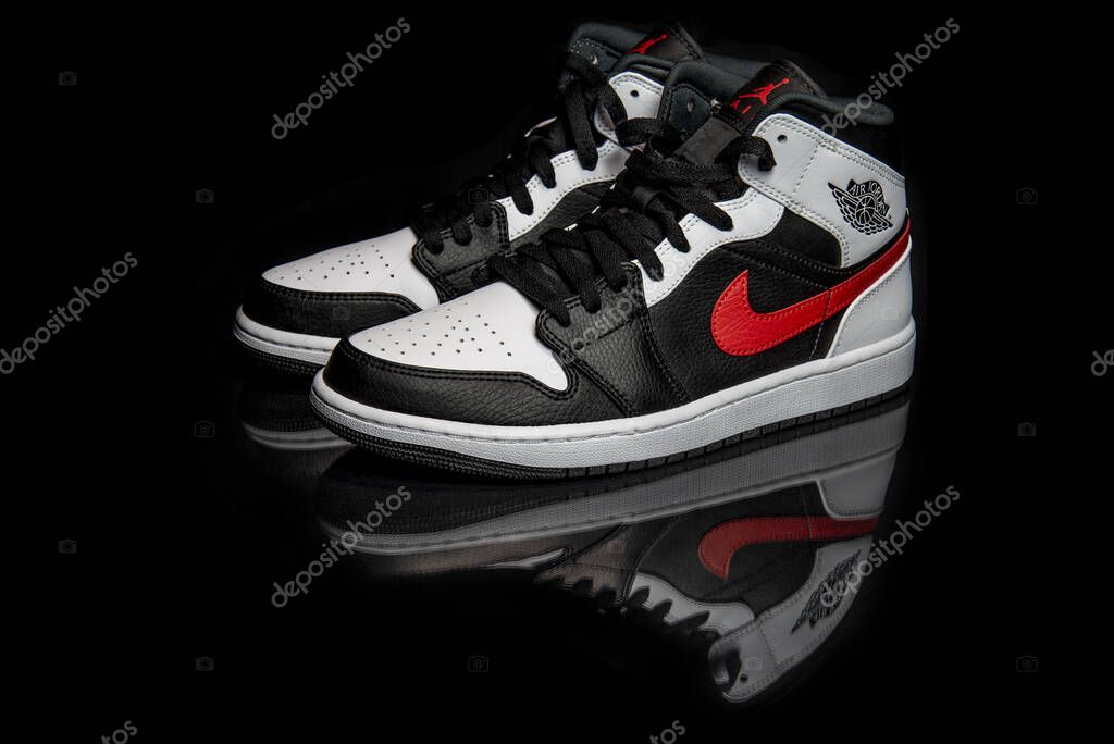 Pavia, Italy - January 31, 2021: Nike Jordan 1 Mid Black Chile Red White shoes studio shot - illustrative editorial
