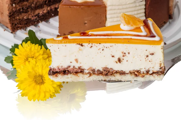 Pièce de gâteau soufflé et fleurs jaunes — Photo