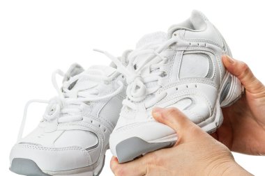 zapatos de los deportes en sus manos