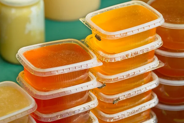 Plastic jars of honey — Stockfoto