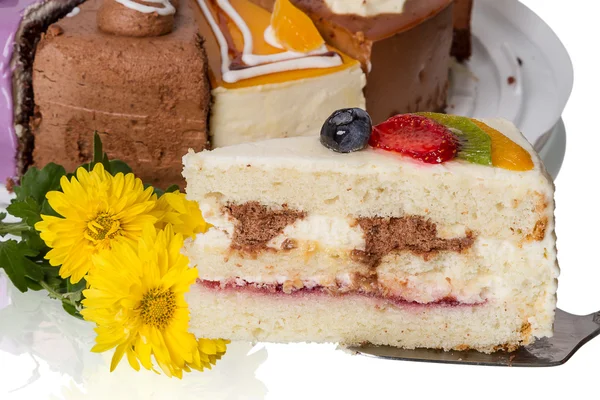 Stück Kuchen mit Obst und Blumen — Stockfoto