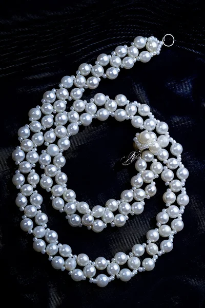 White beads on a black cloth — Stock Photo, Image