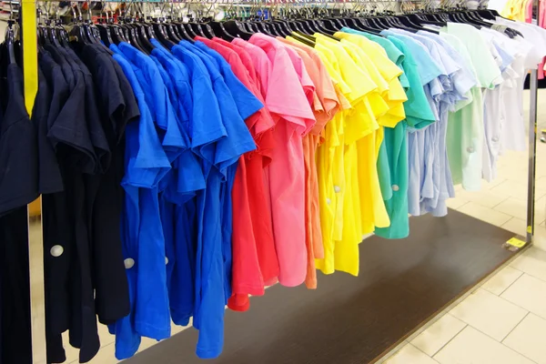 Camisas esportivas coloridas em um cabide na loja — Fotografia de Stock