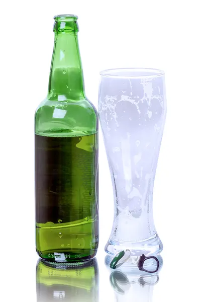 Бутылка пива и пустой стакан — стоковое фото