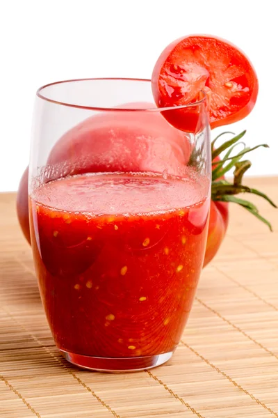 Jus de tomate dans un verre et tomates — Photo