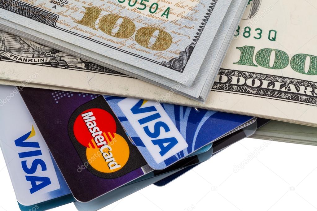 Tambov, Russian Federation - May 25, 2014: Dollars and credit cards with the logos of Visa and Mastercard. Visa and Mastercard are a two biggest credit card companies in the world.