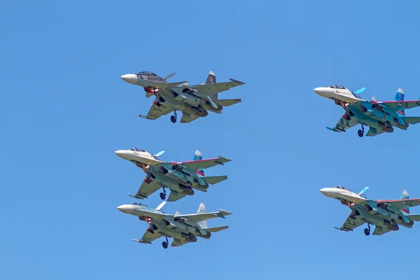 Su-30 en vier Soe-27 in de blauwe hemel — Stockfoto