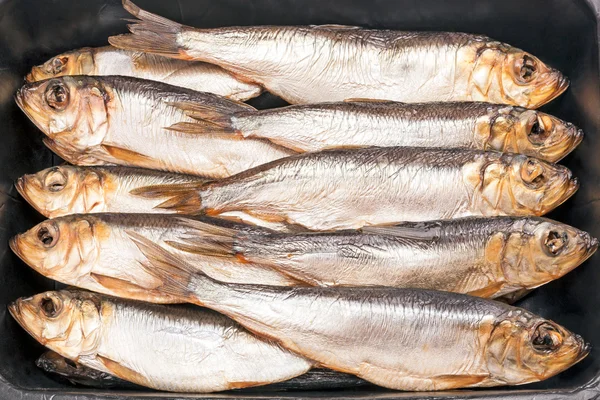 Uzené ryby na černém pozadí — Stock fotografie