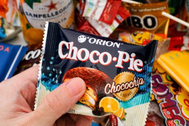 Tambov, Rusya Federasyonu - 30 Ekim 2020 Orion Choco Pie Chocochip ve portakallı çerez keki. Arka planda bir sürü tatlı atıştırmalık. 