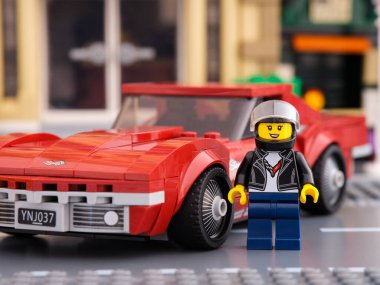 Tambov, Rusya Federasyonu - 02 Temmuz 2021 Lego 1968 Chevrolet Corvette yarış arabası sürücüsü minifiki LEGO Speed Champions tarafından arabasının yanında duruyor.