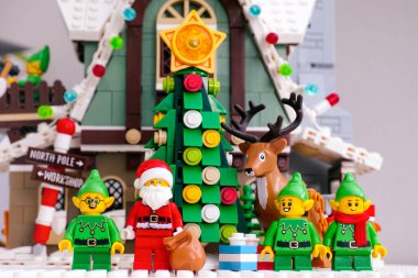 Tambov, Rusya Federasyonu - 08 Ocak 2021 Lego Noel Baba, üç Elf ve Ren geyiği Noel ağacının yanında duruyor Elf Kulübü Evi 'nin karşısında
