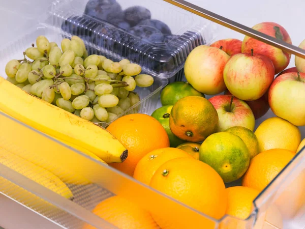 果物でいっぱいの冷蔵庫の引き出し オレンジ みかん ブドウ バナナ リンゴ プラム — ストック写真