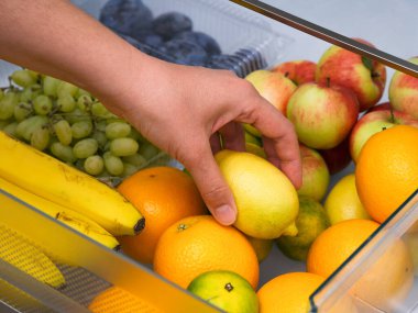 Buzdolabından meyve dolu limon alan bir kadın. Kapat.. 