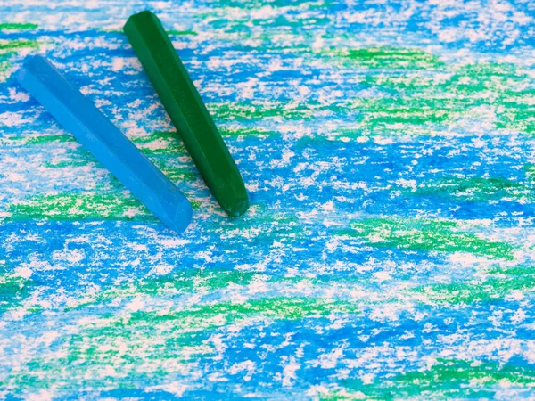 Blue and green oil pastels on a handdrawn oil pastel painting.