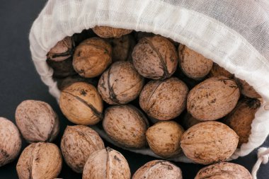 Siyah arka planda tekstil poşetinde ceviz. Yakın plan. 