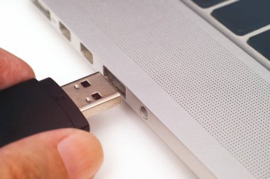 Bir kişi USB belleği bir dizüstü bilgisayara yerleştiriyor