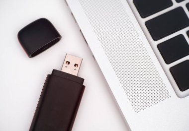 USB Flaş bellek masadaki dizüstü bilgisayarın yanında.