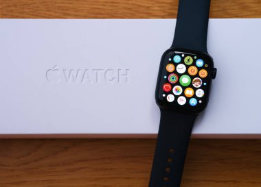 Tambov, Russian Federation - December 14, 2021 An Apple Watch series 7 with apps on its screen lying on its box. Wooden background.