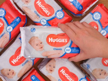 Tambov, Russian Federation - December 21, 2021 Woman hand taking one Huggies wet wipes pack from heap