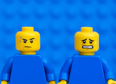 Tambov, Rusya Federasyonu - 17 Ekim 2021 - İki Lego minyatürü - biri ter damlalarından dolayı sert, diğeri mavi arkaplandan korkuyor. Yakın plan..