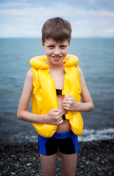Улыбающийся мальчик в спасательном жилете — стоковое фото