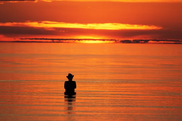 Silhouette of a fisherman in the sea — Stock Photo, Image