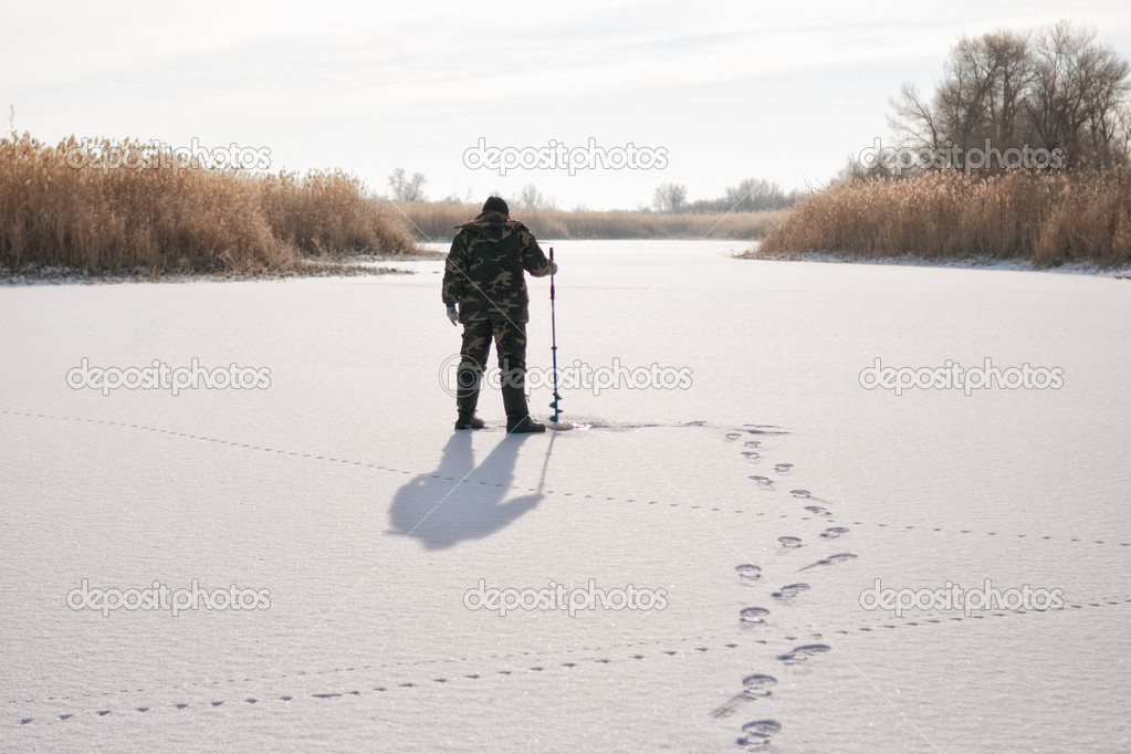 Ice fisherman on winter lake