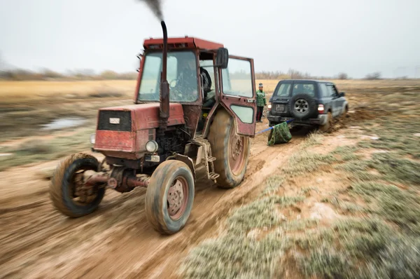 Traktor húzza az elakadt suv — Stock Fotó