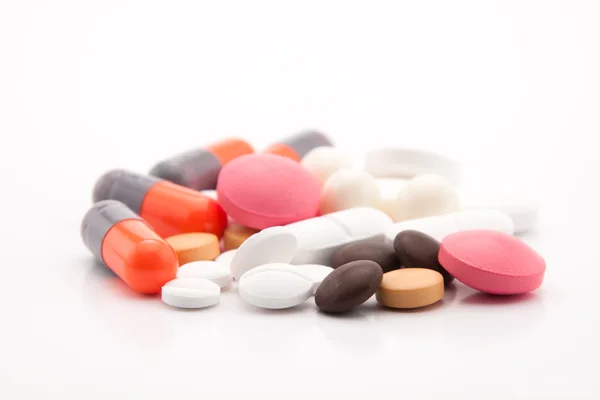 Pilules colorées sur fond blanc — Photo