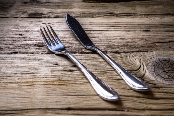 Fischbesteck auf rustikalem Holztisch — Stockfoto