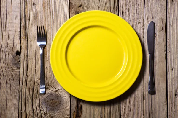 木製のテーブルに刃物と黄色のプレート — ストック写真