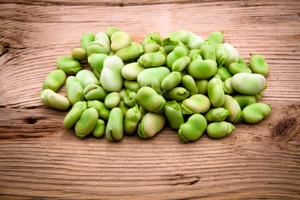 Färska bondbönor på gamla trä bakgrund — Stockfoto