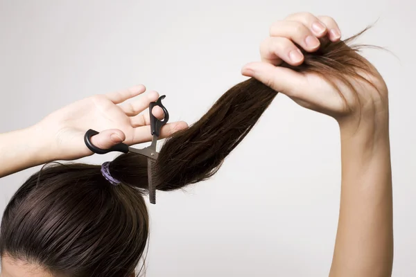 Woman cutting her pony tail — Stock Photo, Image