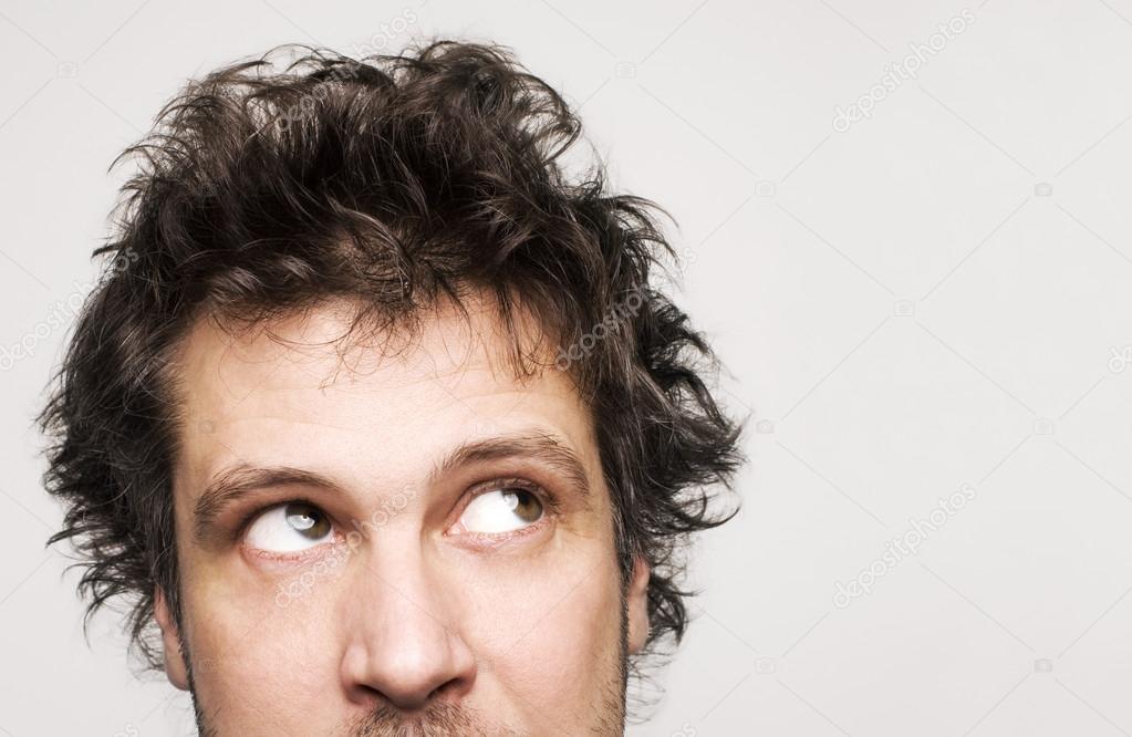 Closeup of worried mans face and hair eyes wide open