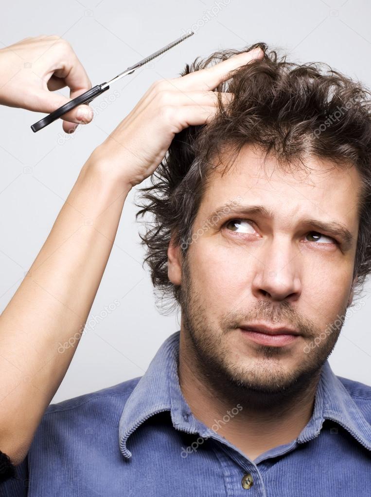 Closeup of worried man face, scissors and hair