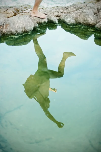 Reflection of a jumper over the cliff on the beach — Stock Photo, Image