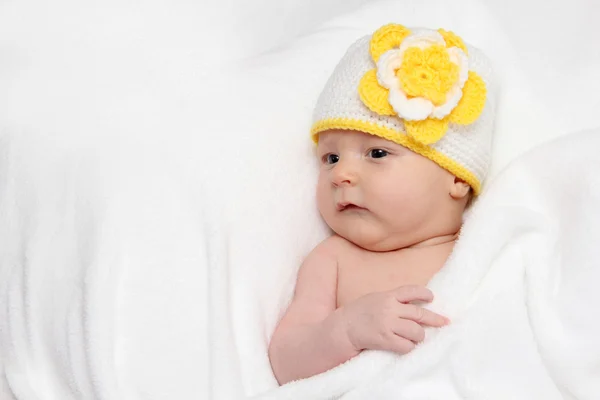 Baby lies in bed — Stockfoto