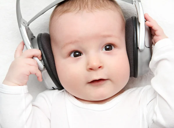 Dziecko słuchania muzyki na plecach — Zdjęcie stockowe
