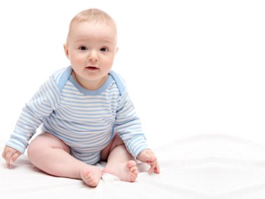 Beyaz yatakta oturmuş çocuk