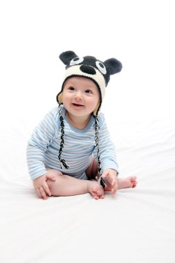 güzel gülen mutlu bebek çocuk knitte beyaz yatakta oturup...