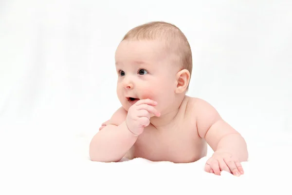 Schönes glückliches Baby liegt auf weißer Decke — Stockfoto