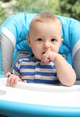 Bebek sandalyede oturuyor.