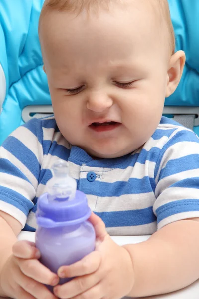 Baby mit Milchflasche unglücklich lizenzfreie Stockbilder