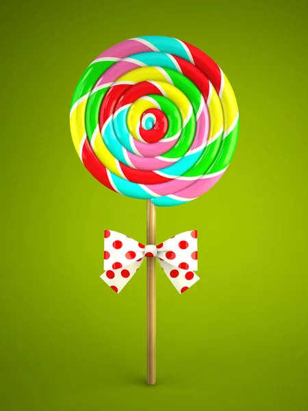 Reainbow lollipop with bow on green background — Stock Photo, Image