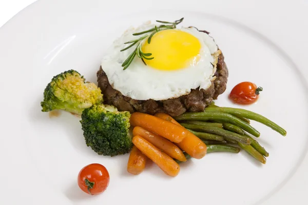 Patty, cooked vegetables and fried eggs — Stock Photo, Image