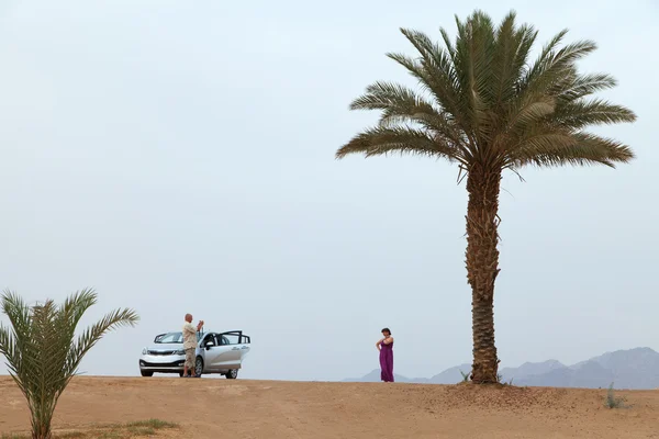 Los turistas son fotografiados en un oasis. Vista de las montañas y — Foto de Stock