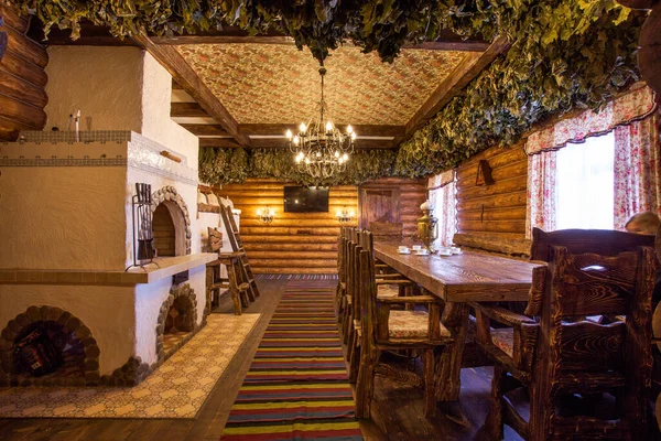 Interior of a wooden Russian bath. Luxurious and cozy interior of a wooden Russian sauna with a real Russian stove. It is a tradition to drink tea from a samovar in a Russian bath.