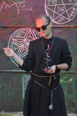 Rahip gibi giyinmiş bir adam. Cadılar Bayramı resmi. Sihir eksikliği.