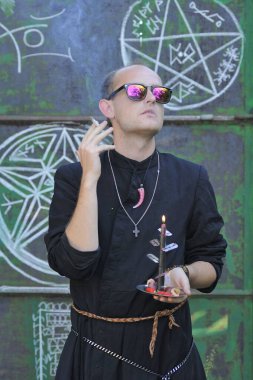 Rahip gibi giyinmiş bir adam. Cadılar Bayramı resmi. Sihir eksikliği.